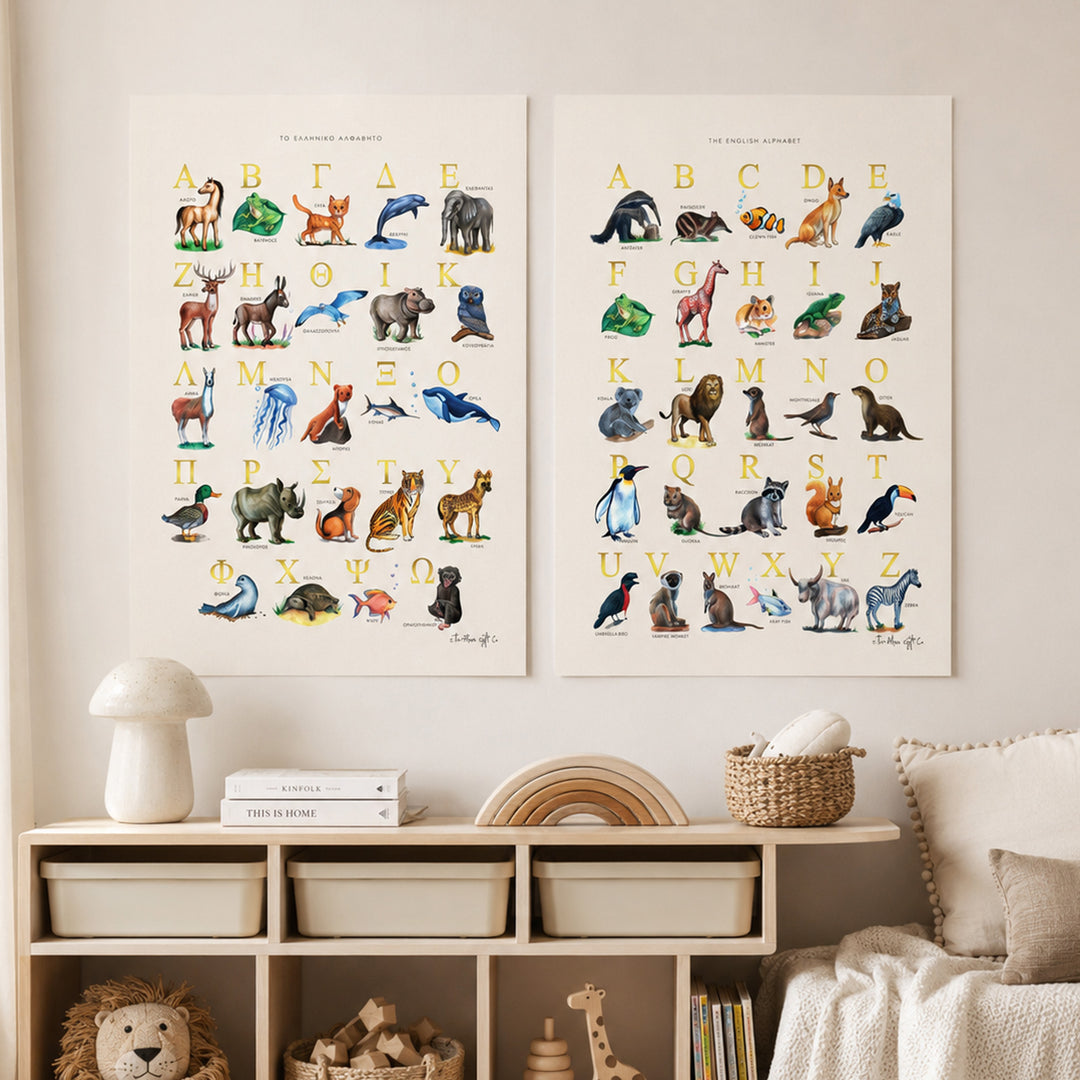 Two vertical animal alphabet art prints displayed side by side on a beige wall above a wooden storage cabinet in a styled nursery or children's room. The prints feature colorful watercolor illustrations of animals paired with uppercase letters and numbers, with the title 'THE ANIMAL ZOO ALPHABET' at the top of each print.