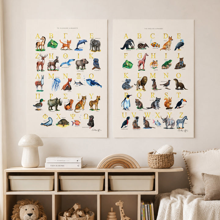 Two vertical animal alphabet art prints displayed side by side on a beige wall above a wooden storage cabinet in a styled nursery or children's room. The prints feature colorful watercolor illustrations of animals paired with uppercase letters and numbers, with the title 'THE ANIMAL ZOO ALPHABET' at the top of each print.